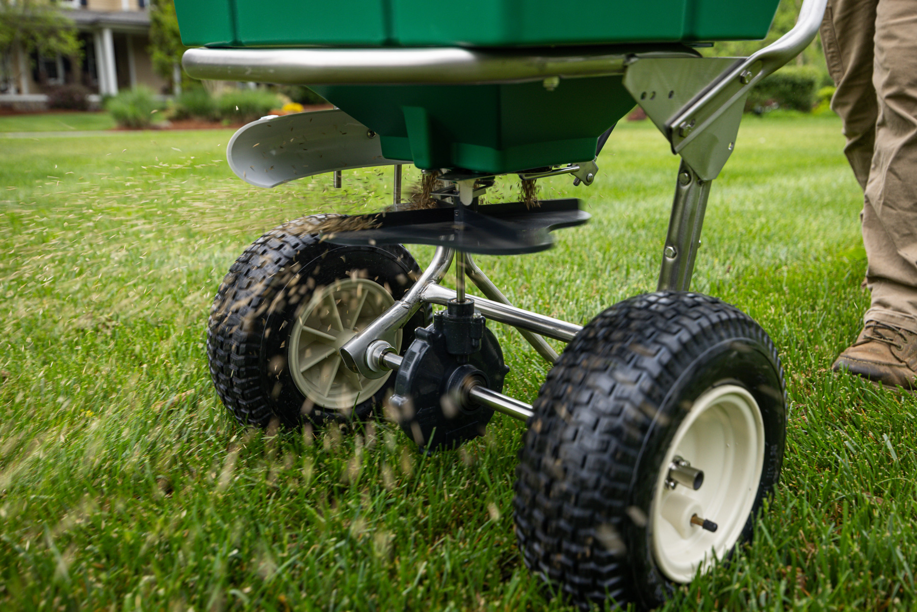 walk behind spreader putting down new grass seed