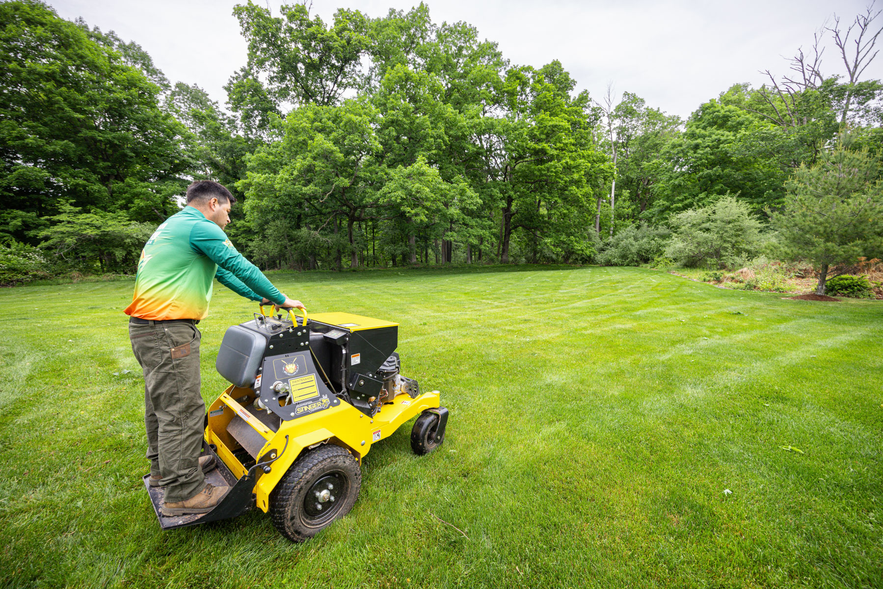 professional lawn care technician performing aeration and overseeding in Central New Jersey